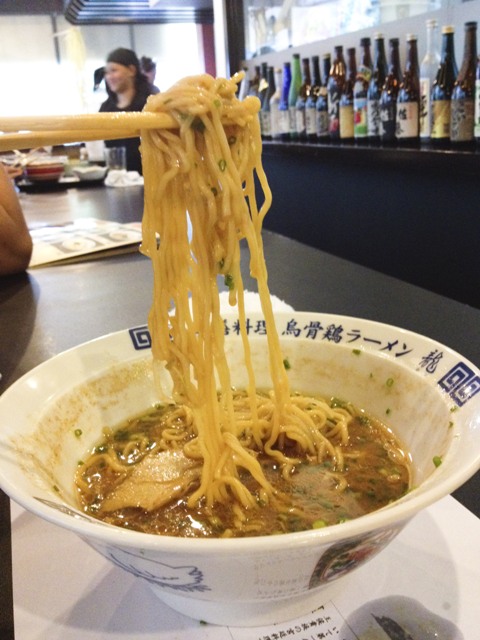 Ramen noodles being held by chopsticks