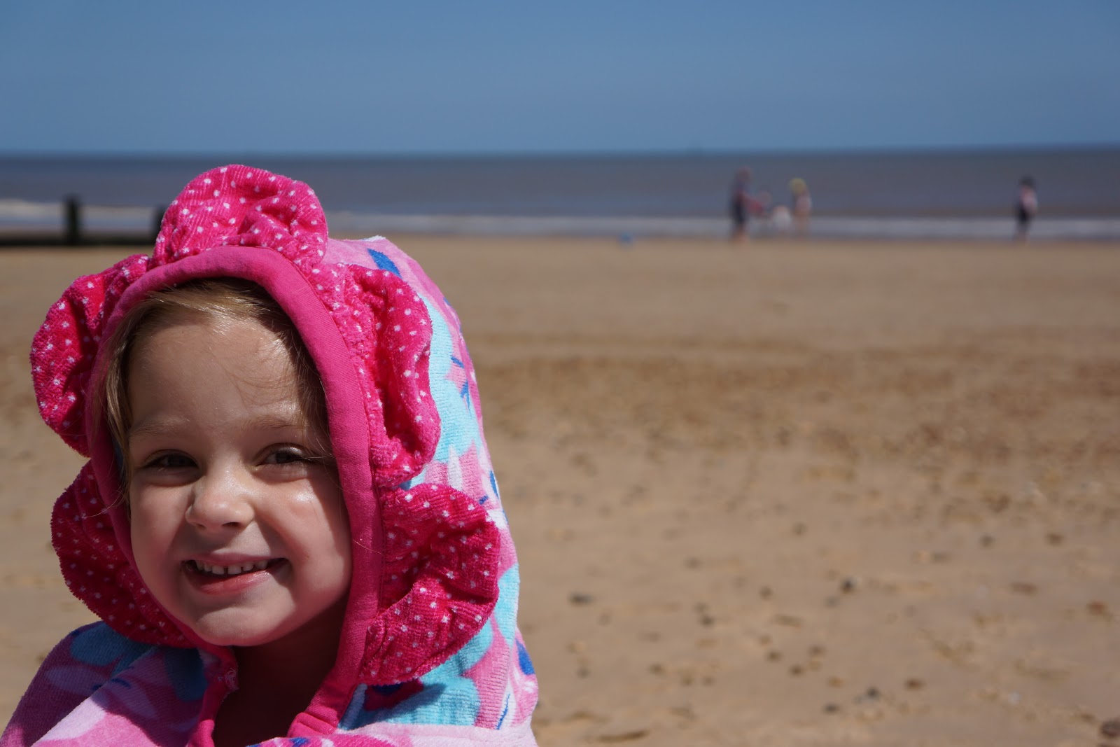 toddler girl in pink flower towel poncho from boots