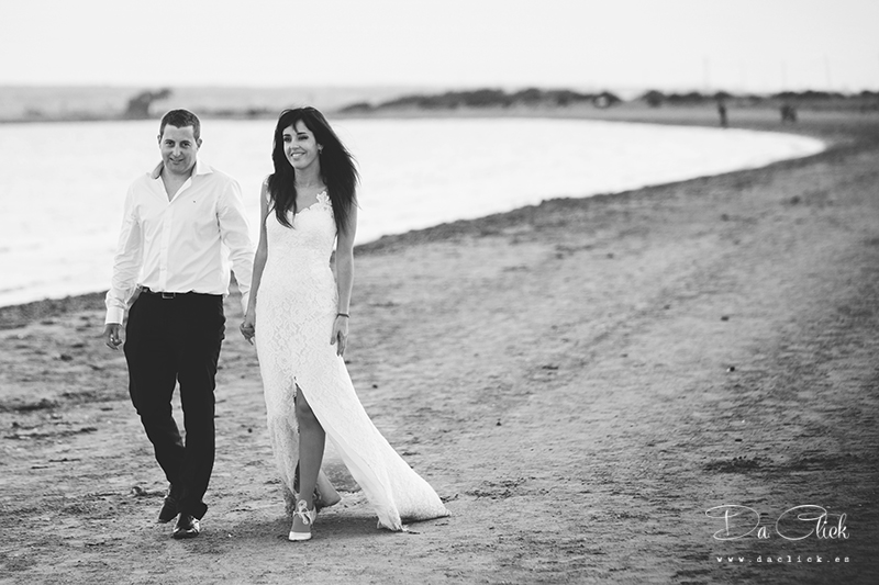 pareja de novios caminando por la arena