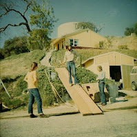 Gary's house (on the hill) and the guys getting ready to move a piano up to it