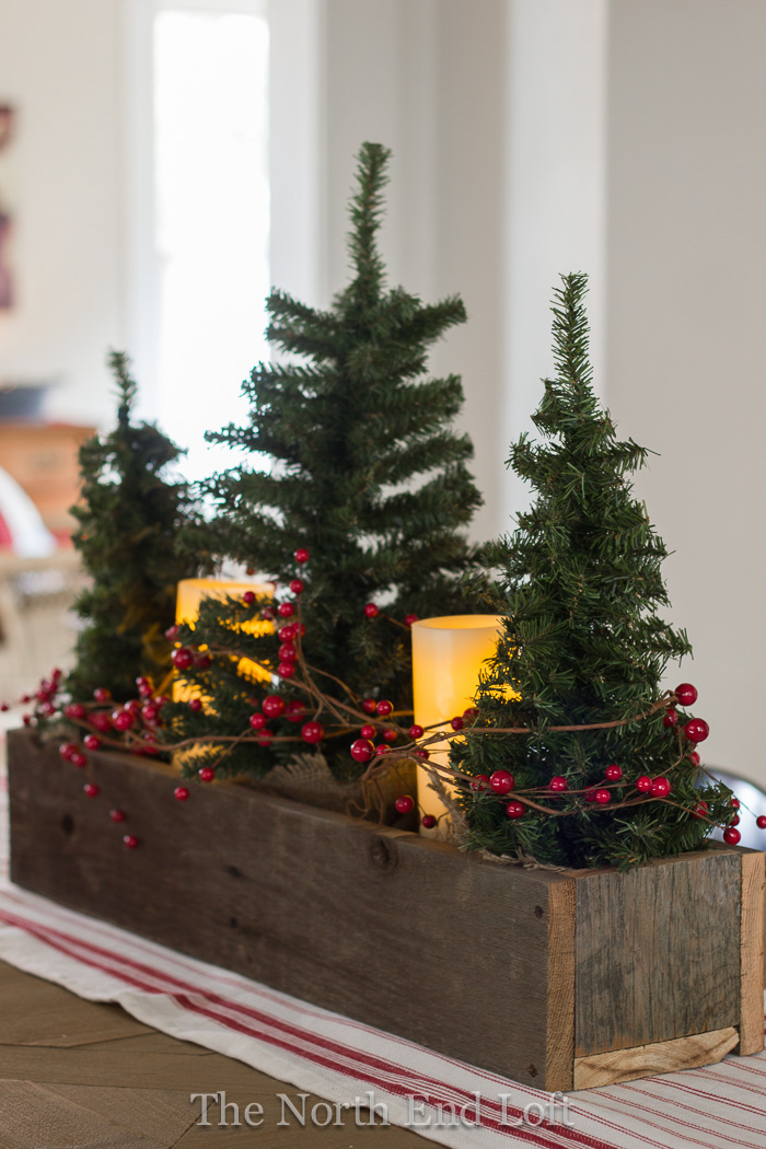 Festive Christmas centerpieces arrangement with candles, ornaments, and greenery