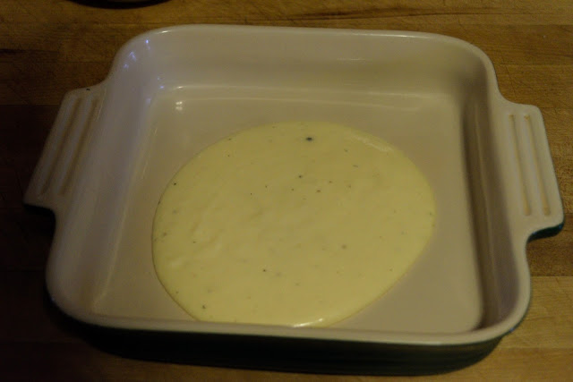 Cheese sauce being added to bottom of the baking dish. 