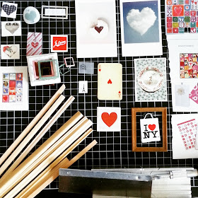 Flat lay of a selection of lengths of miniature picture framing, a hobby saw and mitre box and a collection of small pictures with hearts in them with a stack of one-twelfth scale frames.