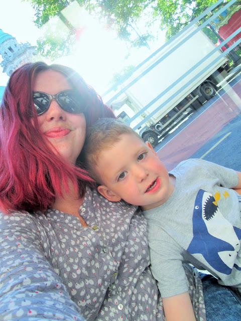 D and I at a bus stop with the sun behind us smiling for a selfie (our Mummy and Me Photo for May)