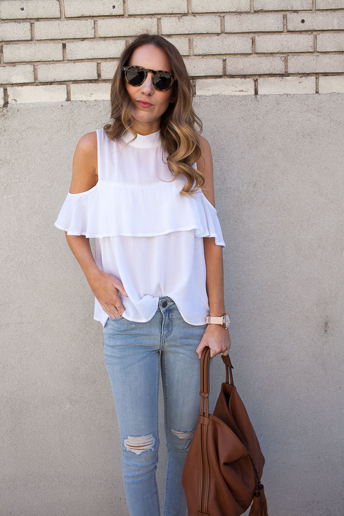 A cold shoulder ruffle top with distressed denim and espadrilles. 