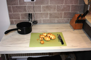 Picture of worktop with potatoes ready to peel and chop