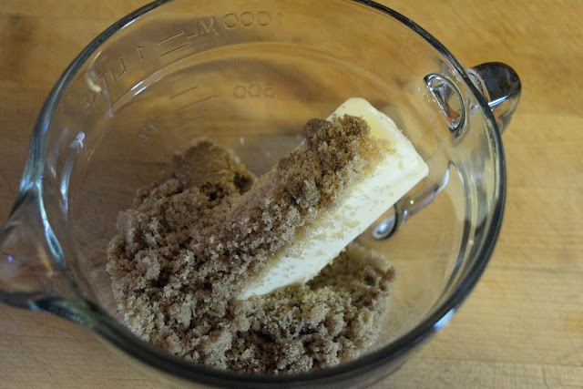 A stick of butter and brown sugar in a mixing bowl. 