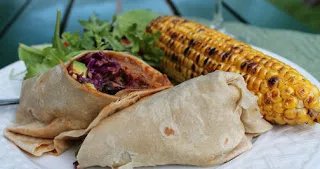 The pulled pork wrap with salad and corn on the cob.