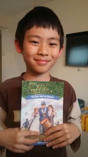 Boy with new book, his first Magic Tree House Book