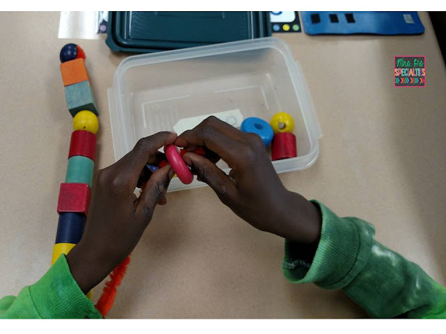 photo of student stringing beads onto a pipe cleaner