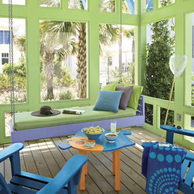 This bright and colorful coastal porch has vibrant greens and blues, perfect for a relaxing beach day