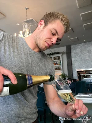 waiter Greg pours sparkling wine at The Dorian in San Francisco, California