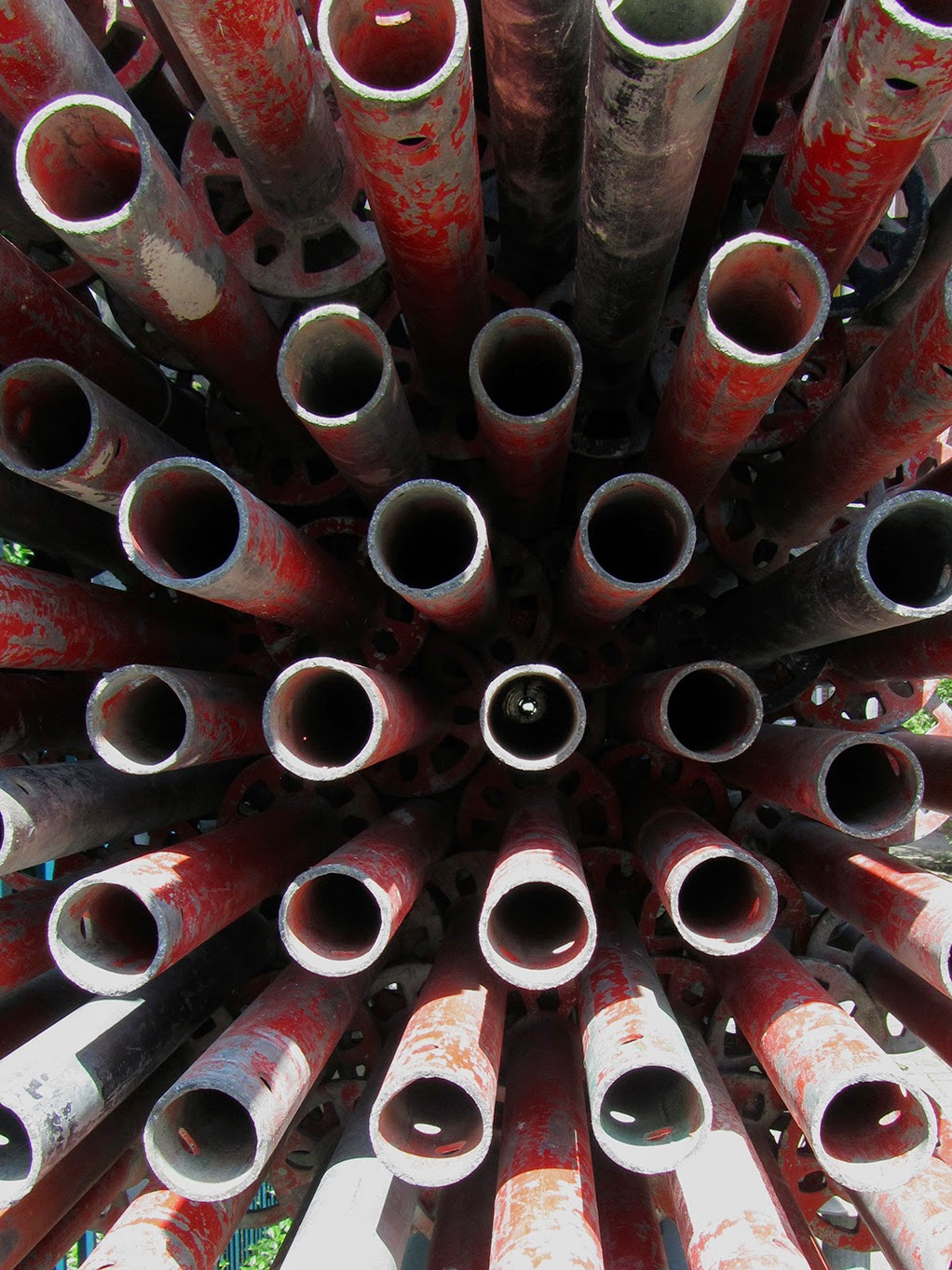 stacked red iron pipes, frontal view