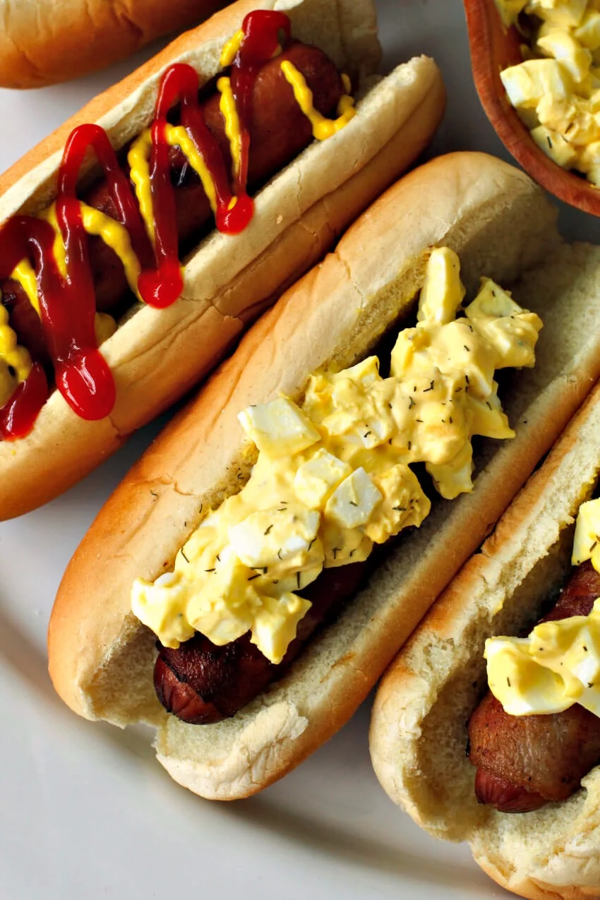 Bacon Wrapped Egg Salad Dogs are made by wrapping hot dogs with smoky bacon and topping them with creamy egg salad. You'll want to make this delicious spin on the classic hot dog all summer long! #ad #hotdogs