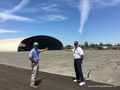 Andy Werback and W. David Ford point to Butler hangar at Pacific Coast Air Museum in Santa Rosa, California