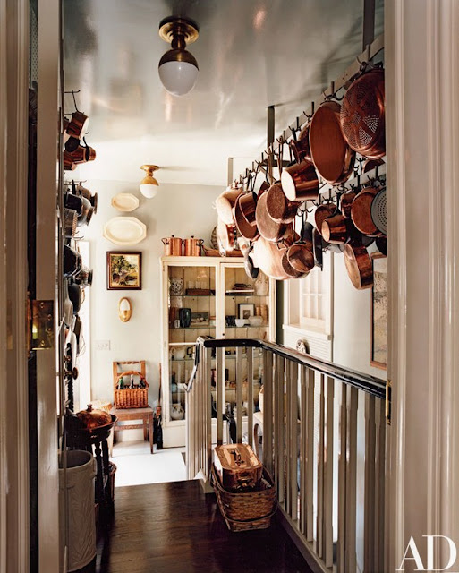 This must be the back entrance into a kitchen. Copper cookware hanging and displayed everywhere