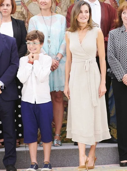 Queen Letizia wore Adolfo Dominguez wrap dress with frayed edges and she wore carolina herrera suede pumps