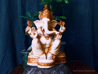 Lord Ganesha Mini Statue On The Stone With Tiny Decorative Flower Plants In The Room