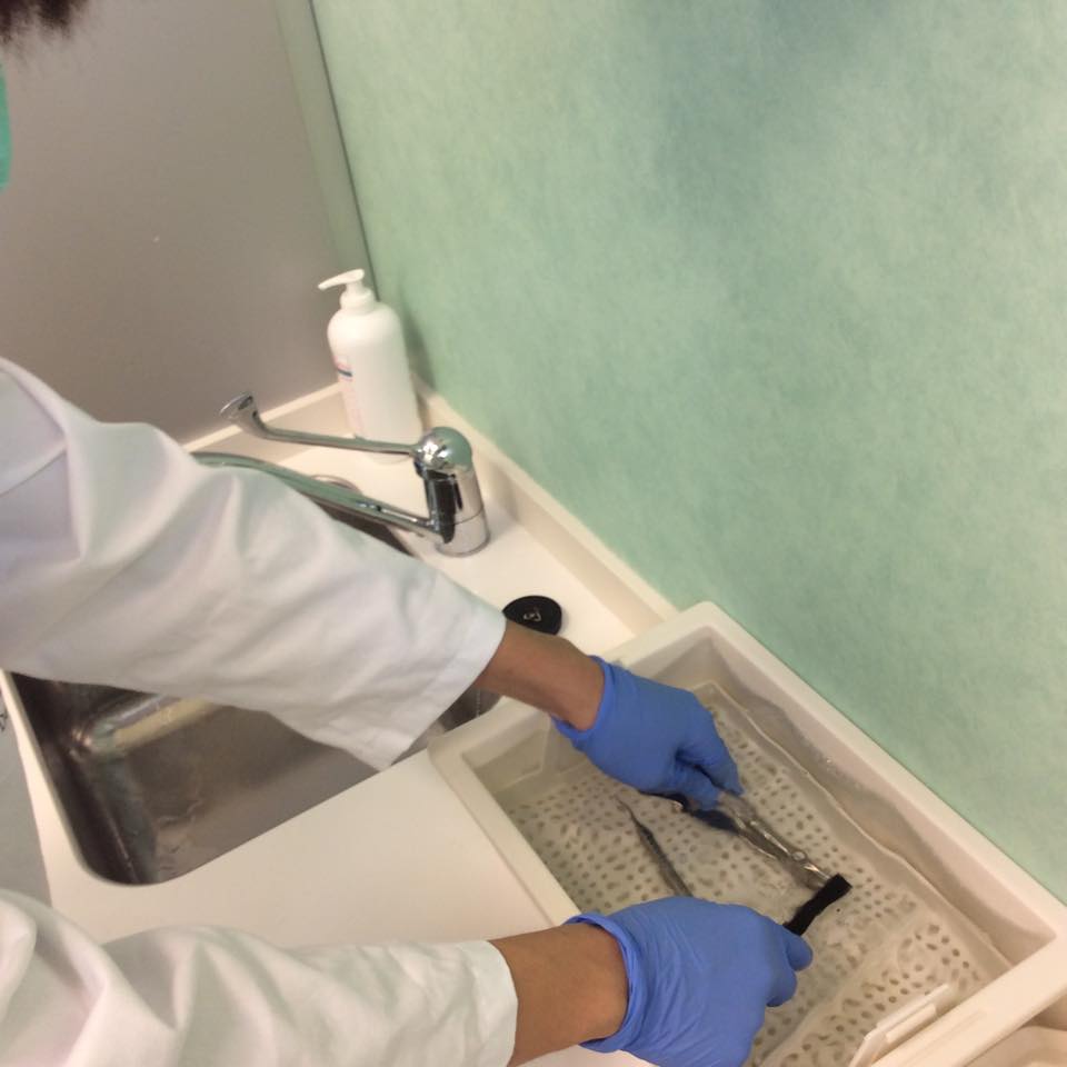 Hsien cleaning the dental chair and instrument