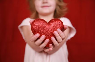 littl girl holds out sparkly heart