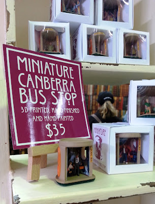 Stack of boxed model Canberra bus stops on a market stall.