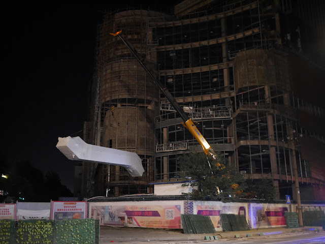 crane lowering an escalator at a shopping mall construction site in Ganzhou