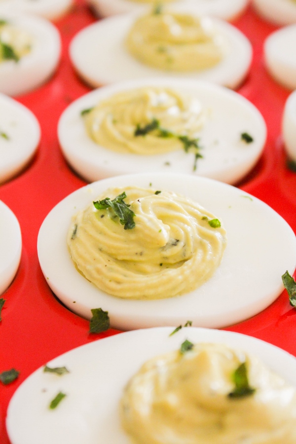 These rich and creamy Pesto Deviled Eggs are full of flavor and lightened up with the addition of Greek yogurt. 