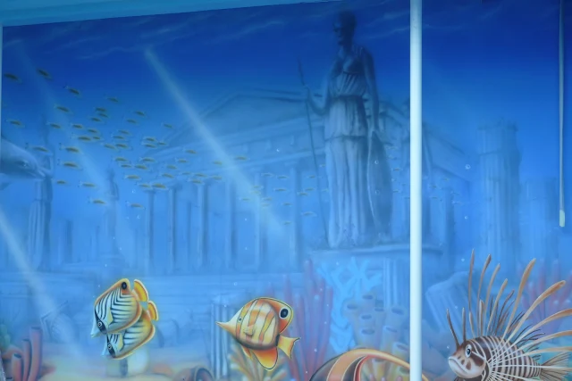 Artystyczne malowanie ściany na basenie, mural przedstawiający rafę koralową i rybki. 