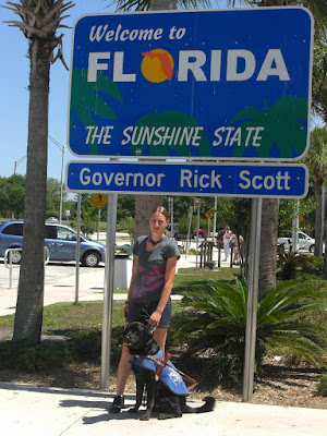 Picture of Rudy & I beside the FL state sign (Rudy is in coat/harness)