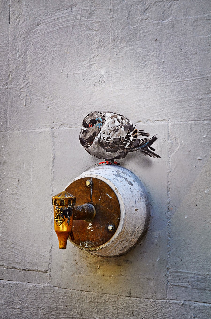 Pigeon graffiti on water tap in Barcelona