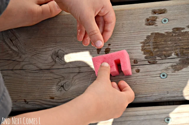 Child stamping with alphabet sponges and water