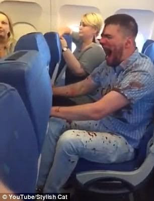 8 Disturbing video of drunken plane passenger covered in blood after he suddenly starts screaming and punching seat in front of him