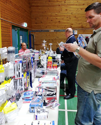 Two men shopping at a stall at a scale model show.