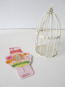 Wire Daiso bird-cage ornament, next to its label.