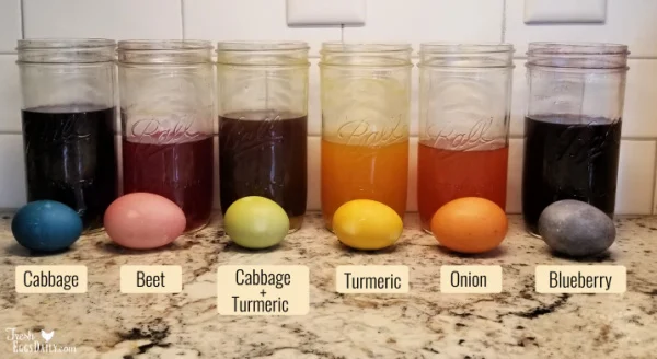 Easter eggs in front of Mason jars of plant dyes