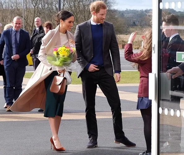 Meghan Markle wore Victoria Beckham cashmere sweater, Mackage Mia sand belted wool coat, Manolo Blahnik shoes and carried Charlotte Elizabeth bag