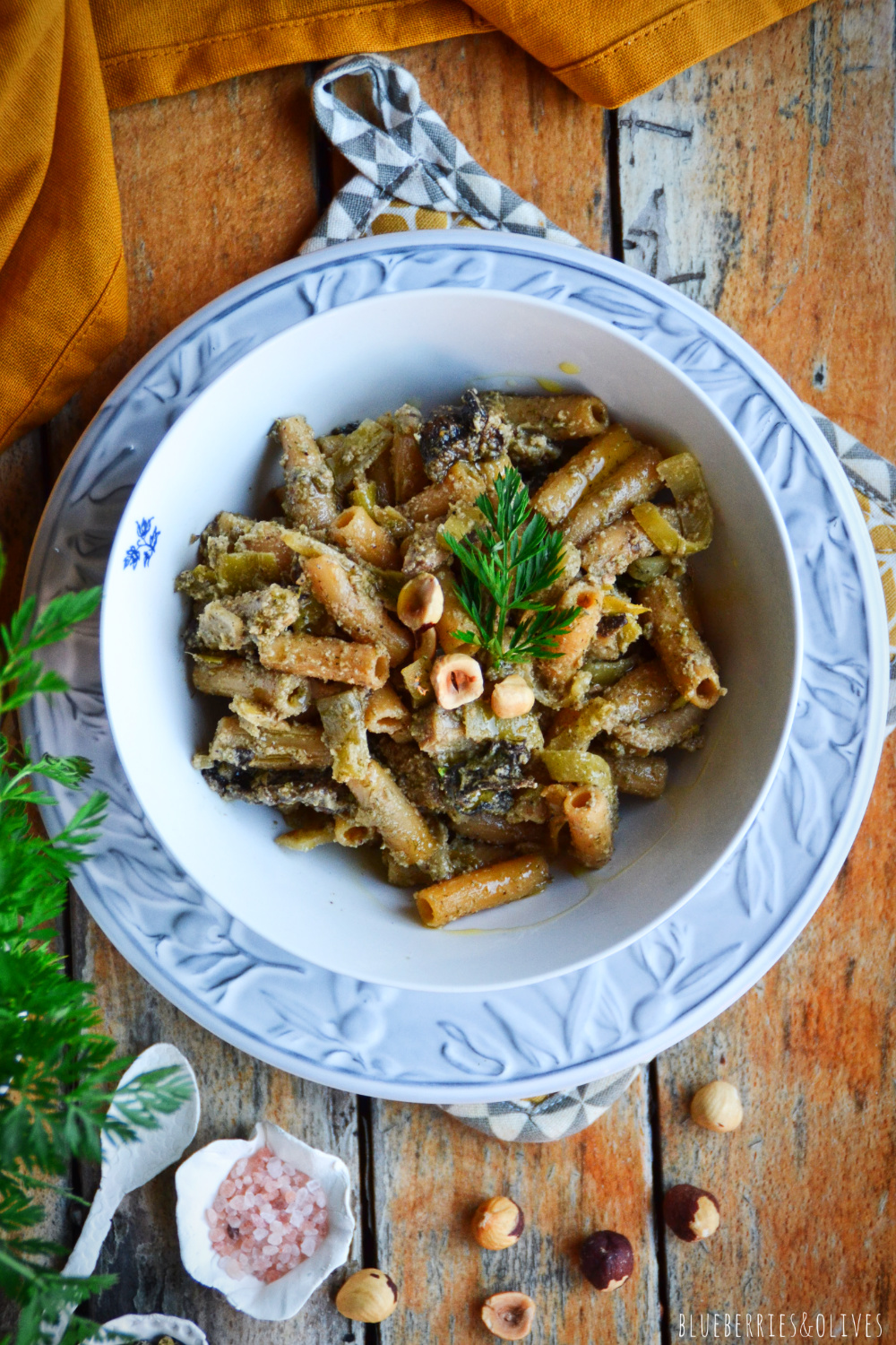 WHITE AND BLUE BOWL OF PASTA WITH FENNEL PESTO AND OLD WOODEN BACKGROUND, YELLOW TABLECLOTH