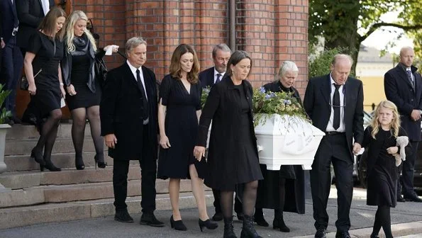 Funeral of Norwegian musician Anne Grete Preus, held at Uranienborg Church in Oslo. Black v-neck half sleeve midi dress