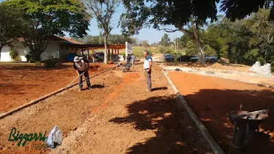 Acertando a terra para a execução da rua com o calçamento com pedras tipo de piso com pedrisco compactado com as guias de pedra, com pedra folheta, em rua da entrada da sede da fazenda em Atibaia-SP e a execução do paisagismo.