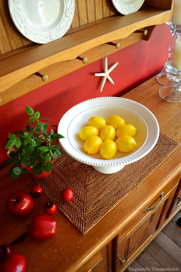 Faux lemons in a bowl on a pine server