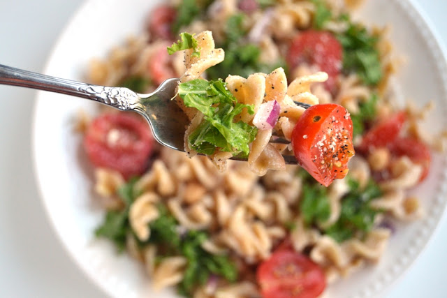 This Kale Caesar Pasta Salad is so simple to make and is full of flavor and nutrients! Filled with whole-wheat noodles, kale, tomatoes, red onion and garbanzo beans. www.nutritionistreviews.com