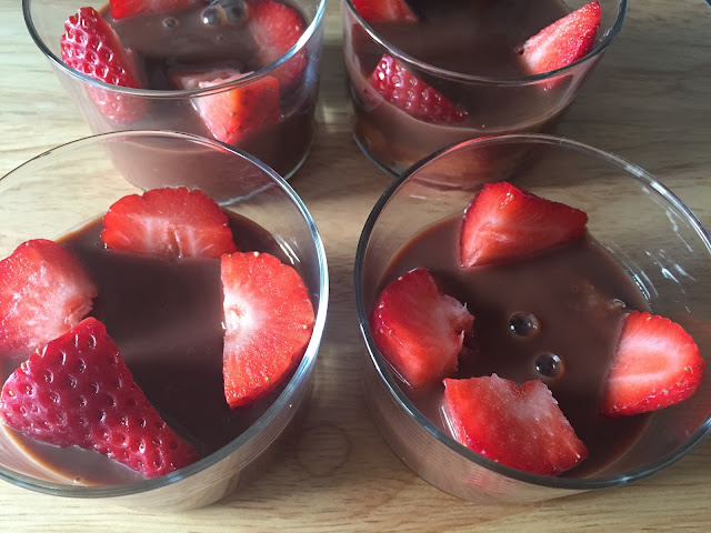 Natillas de chocolate con fresas y nata. Poniendo los trozos de fresa.