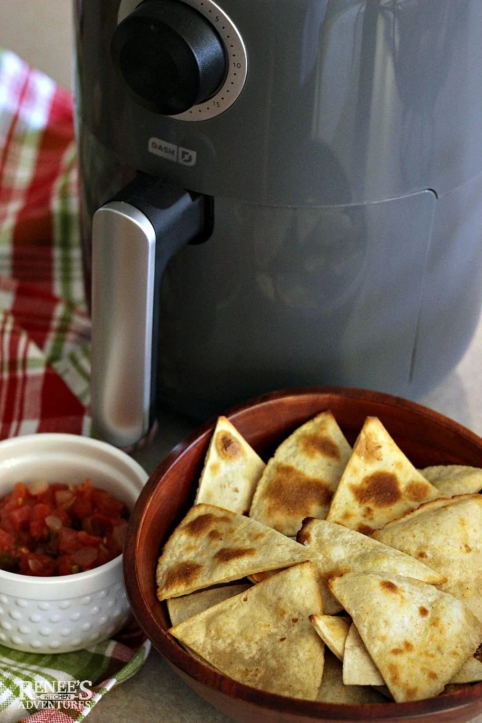 Dash Compact Air Fryer (gray color) with a bowl of corn tortilla chips and salsa in front