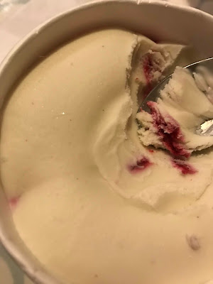 Close up view of a vanilla coloured ice cream with raspberry swirls