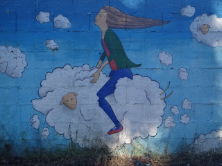 Graffiti con chica vestida de azul en una nube Ordes A Coruña