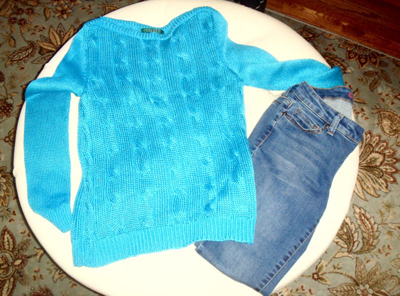 Airport Outfit Blue sweater and jeans on ottoman.