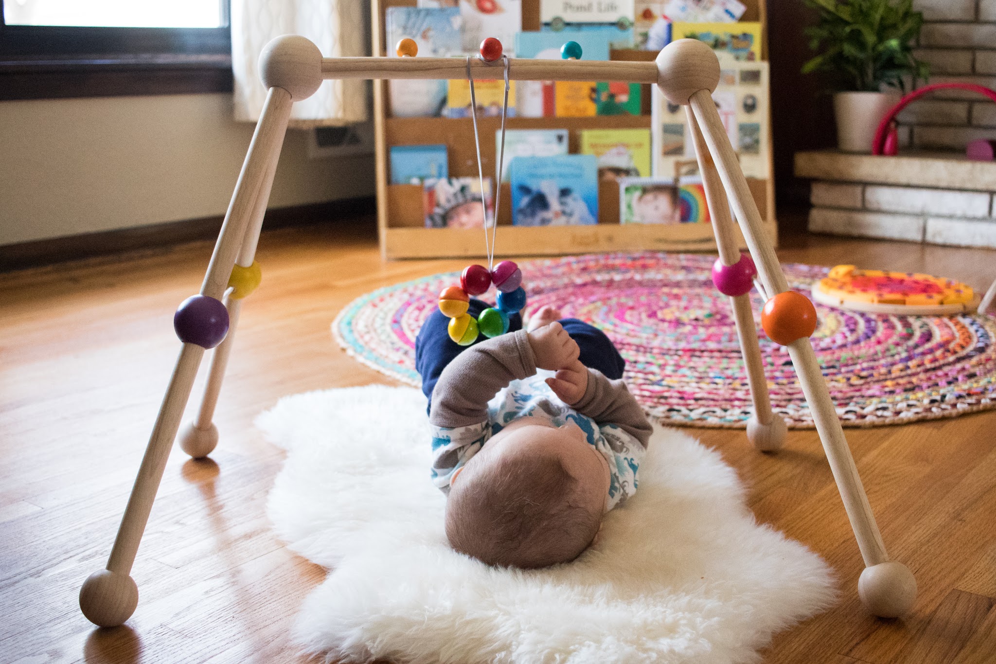Using a baby play gym as an alternative to a movement area can be a perfect option for many Montessori babies. This allows families to stay together while still keeping the baby engaged in a Montessori mobile.