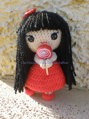 Muñeca realizada a crochet con vestido rojo y piruleta de fieltro