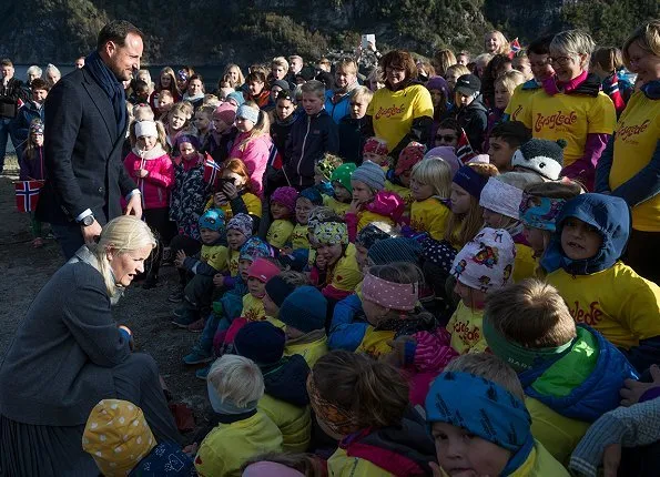 Crown Prince Haakon and Princess Mette-Marit visited Namsskogan, Grong and Namsos. red dress and grey coat