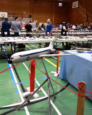 Scale model aeroplane in display in front of tables of scale models.